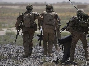 Canadian soldiers with the 1st RCR Battle Group, The Royal Canadian Regiment, help a comrade, center, getting on a helicopter after he was injured in an IED blast during a patrol outside Salavat, in the Panjwayi district, southwest of Kandahar, Afghanistan, Monday, June 7, 2010. The federal government has announced $200 million over six years to support mental health needs of military members, veterans and their families. THE CANADIAN PRESS/AP/Anja Niedringhaus