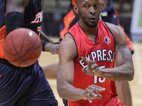 Windsor Express Quinnel Brown passes  in front of  sland Storm Mike Williams in first quarter NBL Canada basketball action from WFCU Centre Thursday November 13, 2014.(NICK BRANCACCIO/The Windsor Star)