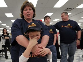 Sunshine Child Eric McLean, 11, sheds a few tears during Sunshine Foundation Dream presentation at Winnners on Tecumseh Road East Monday November 17, 2014. Eric's mother Shawna McLean, top, brother Kyle, 16, and dad Shawn McLean, right, thanked everyone at Winners, who along with HomeSense have been supporting Sunshine as a national partners since 1999. (NICK BRANCACCIO/The Windsor Star)