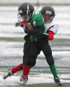 The Titans’ Peyton Holan, left, is tackled by the Giants’ Tashon French-Robert during the tyke division game at Alumni Field Saturday. (DAN JANISSE/The Windsor Star)