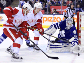 Toronto goaltender Jonathan Bernier, right, makes a save as Detroit's Darren Helm, left, and Tomas Tatar look for a rebound in Toronto Saturday. (THE CANADIAN PRESS/Frank Gunn)