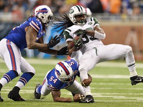 New York's Chris Ivory, right, is tackled by Larry Dean, centre, and Brandon Spikes of the Bills in the fourth quarter at Ford Field. (Photo by Jamie Sabau/Getty Images)