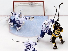 Toronto goalie Jonathan Bernier, left, reaches for the puck as Dion Phaneuf, centre, holds off Pittsburgh's Sidney Crosby Wednesday in Pittsburgh, (AP Photo/Gene J. Puskar)