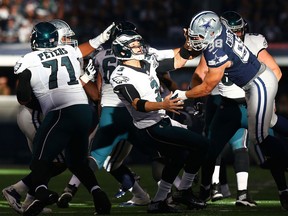 Windsor's Tyrone Crawford, right, of the Dallas Cowboys sacks Eagles QB Mark Sanchez  in the first half at AT&T Stadium on November 27, 2014 in Arlington, Texas.  (Ronald Martinez/Getty Images)