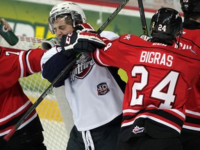 Owen Sound's Daniel Milne, left, and Chris Bigras hit Windsor's Trevor Murphy at the WFCU Centre. (NICK BRANCACCIO/The Windsor Star)