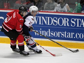 Windsor's Jamie Lewis, right, is checked by Owen Sound's Ethan Szypula in the first period at the  WFCU Centre. (NICK BRANCACCIO/The Windsor Star)