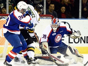 Windsor's Andrew Burns, left, checks London's Chandler Yakimowicz in front of goalie Alex Fotinos Friday in London. (AARON BELL/OHL Images)