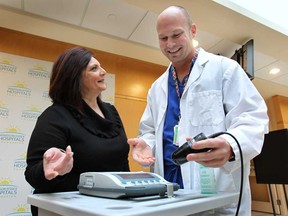 Anita Imperioli, founder and president of In Honour Of the Ones We Love and Jeff Theriault, clinical practice manager at the Windsor Regional Hospital Met Campus check out a bladder scanner that the charitable organization donated on Wed. Nov. 19, 2014. (DAN JANISSE/The Windsor Star)