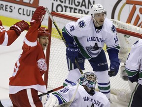 Detroit Red Wings center Stephen Weiss, left, reacts after teammate Pavel Datsyuk scored against Vancouver Canucks goalie Ryan Miller (30) during the second period in Detroit, Sunday, Nov. 30, 2014. (AP Photo/Carlos Osorio)