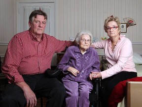 Madelyn Reitzel, 89, centre, who is cared for by her daughter, Jeannie Fauteux, and her son-in-law, Joe Fauteux, at their home in Riverside, are pictured Friday, Nov. 14, 2014.  The family was told that the care they receive by CCAC will be cut in half to one hour a day. (DAX MELMER/The Windsor Star)