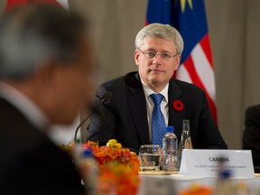 In this file photo, Canadian Prime Minister Stephen Harper listens to United States President Barack Obama deliver opening remarks to members of the Trans Pacific Partnership at the US Embassy in Beijing, China, on Monday, November 10, 2014. (THE CANADIAN PRESS/Adrian Wyld)