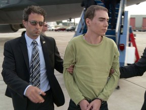 Luka Rocco Magnotta is taken by police from a Canadian military plane to a waiting van on Monday, June 18, 2012 in Mirabel, Quebec. (Canadian Press files)
