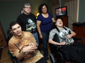 Max Knight-Shank, left, Terry Shank, Shirley Knight and Joshua Knight-Shank (left to right) are photographed in their family home in Windsor on Friday, November 13, 2014. The family is hoping to raise enough money to be able to move Joshua's bedroom out of the front room of the house.                     (TYLER BROWNBRIDGE/The Windsor Star)