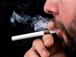 A smoker puffs on an electronic cigarette on Friday, Feb. 7, 2014. (THE CANADIAN PRESS/Andrew Vaughan)