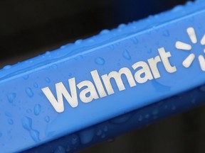 This file photo taken Nov. 14, 2011, shows the rain-soaked handle of a shopping cart outside the Wal-Mart store in Mayfield Hts. Wal-Mart reports quarterly earnings on Thursday, Nov. 13, 2014. (AP Photo/Amy Sancetta, File)