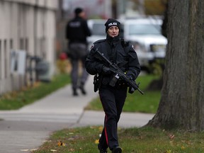 A Windsor police officer armed with an automatic rifle attends an apartment building at 1094 Lincoln Rd. on Nov. 12, 2014. (Nick Brancaccio / The Windsor Star)