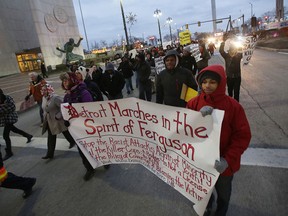 Protester march in Detroit, Tuesday, Nov. 25, 2014 in response to the Ferguson grand jury decision not to indict police officer Darren Wilson in the death of Michael Brown. (AP Photo/Paul Sancya)