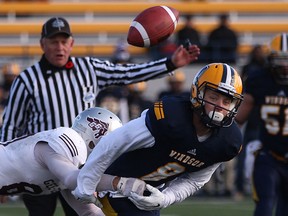 Windsor defensive back Josh Burns is tackled by Ottawa's Ian Stewart, left, after Burns nearly caught an interception during the OUA football quarter-final between the Windsor Lancers and the Ottawa Gee Gees at Alumni Field, Saturday, Nov.1, 2014.  Windsor lost to Ottawa 46-29.  (DAX MELMER/The Windsor Star)
