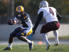 Windsor's Gilbert Stewart, left, tries to get past Ottawa's Tunch Akkaya during the OUA football quarter-final between the Windsor Lancers and the Ottawa Gee Gees at Alumni Field, Saturday, Nov.1, 2014.  Windsor lost to Ottawa 46-29.  (DAX MELMER/The Windsor Star)