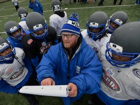 Phillips Academy head coach Troy McAllister speaks to his players during practice on the south side of Chicago. Unlike the powerhouses that normally play for high school football championships, the Phillips Academy Wildcats must lug their helmets and pads to a city park to practice. They have no field of their own. (AP/Paul Beaty)