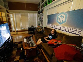 In this Nov. 6, 2014 photo, Robert Schill plays video games in his living room, in Lakeland, Fla.  Schill plays video games nine to five, seven days a week and gets paid for it. (AP Photo/John Raoux)