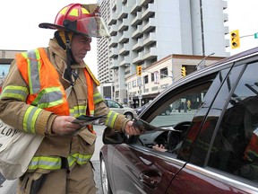 Goodfellow and Windsor firefighter Anthony Revenberg sells newspapers on Ouellette Ave. in Windsor, ON. on Thursday, Nov. 27, 2014.  (DAN JANISSE/The Windsor Star)