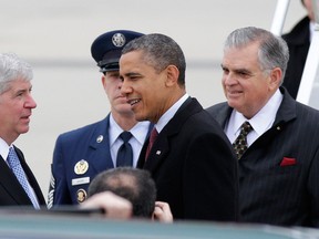 President Barack Obama, accompanied by Transportation Secretary Ray LaHood, right, is greeted by Michigan Gov. Rick Snyder as they arrive at Detroit Metropolitan Airport in Romulus, Mich.  on Dec. 10, 2012. (AP/Duane Burleson)
