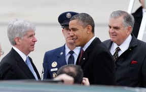 President Barack Obama, accompanied by Transportation Secretary Ray LaHood, right, is greeted by Michigan Gov. Rick Snyder as they arrive at Detroit Metropolitan Airport in Romulus, Mich.  on Dec. 10, 2012. (AP/Duane Burleson)