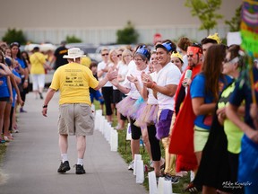 A man is greeted with high-fives as he walks the Survivors’ Lap during the Relay for Life at the Vollmer Centre in 2013. (Courtesy of Mike Kovaliv)