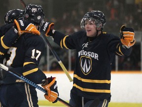 Windsor Lancers, from left, Julian Luciani, Kyle Hope, and Scott Prier celebrate after Luciani scored the opening goal for the Lancers against the McGill Redmen in OUA men's hockey at South Windsor Arena, Friday, Nov. 14, 2014.  (DAX MELMER/The Windsor Star)