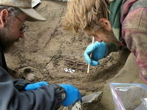 In this Fall 2013 photo released Tuesday, Nov. 11, 2014 by the University of Alaska Fairbanks, professors Ben Potter, left, and Josh Reuther excavate the burial pit at the Upward Sun River site in central Alaska. Researchers have uncovered the remains of two Ice Age infants in Alaska's interior, a discovery archaeologists call the youngest human remains found in northern North America. (AP Photo/University of Alaska Fairbanks, Courtesy of Ben Potter)