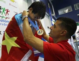 Hou Yushan,from Beijing, China, receivesa  gold medal from Mayor Eddie Francis at the International Children's Games at the Windsor International Aquatic and Training Centre on August 16, 2013. (DAX MELMER/The Windsor Star)