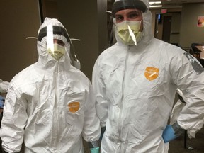Windsor Regional Hospital registered nurses Andre Dafesh and James Rodgers practise donning the protective suits they'd be required to wear to treat an Ebola patient Tuesday, November 11, 2014. (Brian Cross/The Windsor Star)
