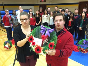 Becky Bryans, vice-president, and Ethan Raymond, president of Kennedy Collegiate Student Forum, hold a wreath in front of students and staff who helped with the Remembrance Day ceremony at the school on November 11, 2014. (Craig Pearson/The Windsor Star)