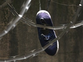 A media tour of the former Windsor Jail was held Tuesday, Nov. 4, 2014, in Windsor, ON. A shoe in the barbed wire that surrounds the outdoor recreational is shown. Prisoners routinely threw them up in the wiring.  (DAN JANISSE/The Windsor Star)