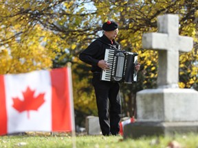 Len Wallace plays the accordion during his annual remembrance day visit at Windsor Grove Cemetery in Windsor, Ontario on November 11, 2014.  Wallace pays tribute each year to remember fallen soldiers. (JASON KRYK/The Windsor Star)