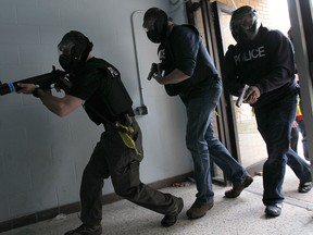 The Windsor Police Service held a training exercise on Thursday, Nov. 6, 2014, to simulate a live shooter situation at a school. Officers move towards the conflict during the exercise. (DAN JANISSE/The Windsor Star)