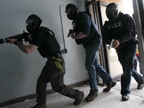 The Windsor Police Service held a training exercise on Thursday, Nov. 6, 2014, to simulate a live shooter situation at a school. Officers move towards the conflict during the exercise. (DAN JANISSE/The Windsor Star)