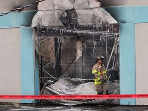 A firefighter checks out the damage at the Mayson Machining manufacturing facility at 3706 Sandwich St. on Nov. 18, 2014. (Dan Janisse / The Windsor Star)