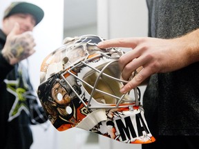 In this Nov. 3, 2014 photo, Philadelphia Flyers goalie Steve Mason, right, looks at his new mask painted by Franny Drummond, left, at the team's NHL hockey training facility in Voorhees, N.J. (AP Photo/Matt Rourke)