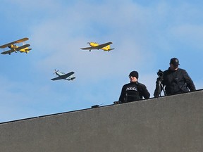 Canadian Historical Aircraft Association planes fly overhead of rooftop police officers during the downtown Remembrance Day ceremony on Tuesday, Nov. 11, 2014, in Windsor, ON. (DAN JANISSE/The Windsor Star)