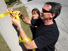 Files: Gary and Debbie Dufour tie a yellow ribbon to a pole along Forest Glade Drive in Windsor on Wednesday, September 10, 2008. Volunteers tied yellow ribbons to all the poles along the street near where the funeral procession for Andrew Grenon passed through.  (Windsor Star/Tyler Brownbridge)