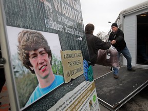 An image of the late, Matthew Joseph Rawlings, is displayed on a sign as his stepfather Bryan LaMarsh and father, Paul Rawlins unload donated sleeping bags to the Street Help Homeless Centre of Windsor on November 25, 2014. (JASON KRYK/The Windsor Star)