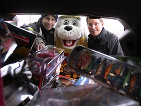 Chrysler Canada's Windsor Assembly Plant employees donated more than $30,000 worth of items to Sparky's Toy Drive on Thursday, Nov. 20, 2014. The toys will benefit local needy children during the holiday season. Windsor Fire and Rescue Services firefighter John McRae (L), coordinator of the Sparky Toy Drive, Sparky the mascot and Chrysler plant manager Mike Brieda help fill a minivan with toys during the event.    (DAN JANISSE/The Windsor Star)