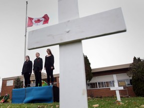 Desiree Dietz, left, Jaggar Ford-Klein, and Ashley MacLachlan stand at attention in front of St. John Catholic School in Windsor, Ontaro on November 11, 2014.  Grade 7 and 8 students participated in the Remembrance Day tribute with rotating shifts from 8am until 6pm  Tuesday.  (JASON KRYK/The Windsor Star)