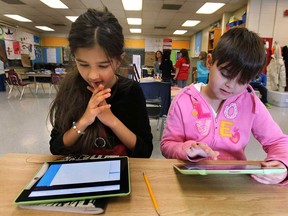 Eastwood Elementary School students Gurkamal Minhas, 8, (L) and Bianca O'Quinn Lundy, 7, work on iPad computers on Thursday, Nov. 20, 2014. (DAN JANISSE/The Windsor Star)