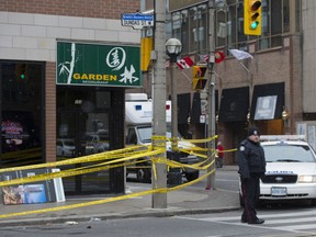 Toronto Police investigate the scene of a triple shooting that occurred in the early morning hours at Garden Restaurant at Dundas Street and Chestnut Street in Toronto, Ontario on Sunday, November 16, 2014. A 34-year-old man was killed in the shooting.   (Laura Pedersen/National Post)