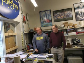 Mike Morencie, left, and Mike Urban of The Trophy Boys check out a broken window Wed. Nov. 12, 2014, where a break in occurred recently. Computers containing decades worth of business information and logos were stolen. (DAN JANISSE/The Windsor Star)