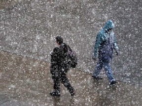 Pedestrians walk along Ouellette Avenue during a snow squall in downtown Windsor on November 13, 2014. There isn't too much snow accumulation in the area but we're in for bitter cold weather on Wednesday.(JASON KRYK/The Windsor Star)