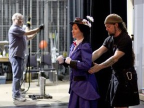 Flying director Stu Cox, right, helps Kathy Roberts, dressed as Mary Poppins, to prepare to take flight. (RICK DAWES / The Windsor Star)